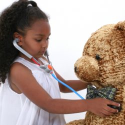 Adorable Little Playing Doctor To A Teddy Bear Over White. Shot with the Canon 20D.